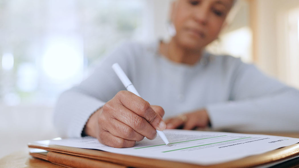 Personne qui tient un stylo et remplit un document